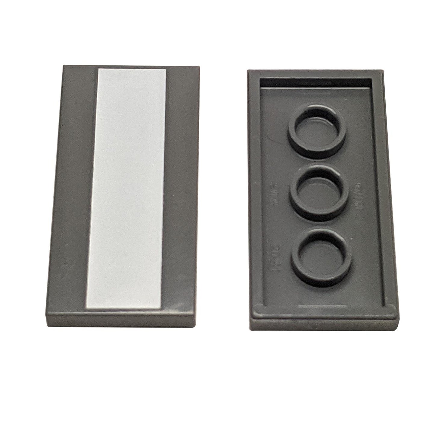 Two dark gray LEGO Tile 2x4 pieces (87079); one showing the smooth top with a vertical white stripe.
