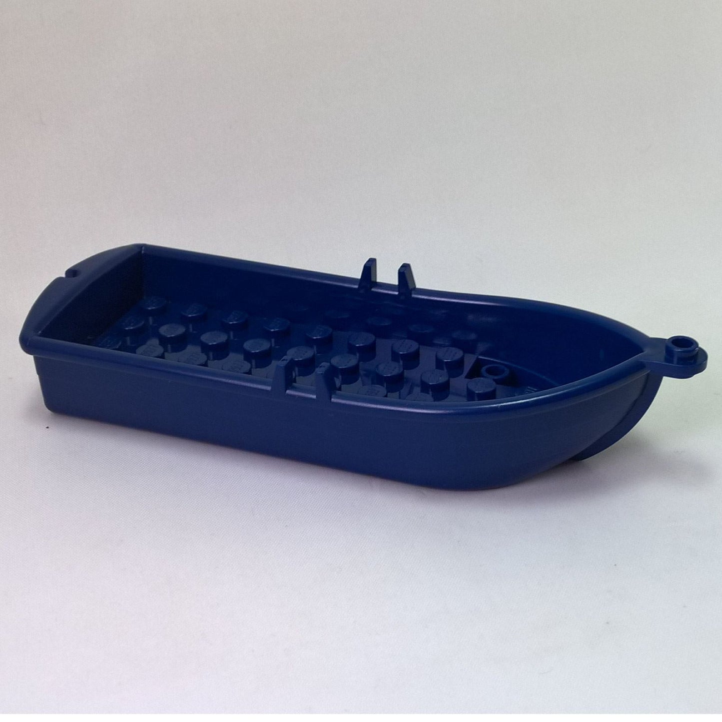 Dark blue LEGO Boat 2551, side view showing oarlocks and interior studs.