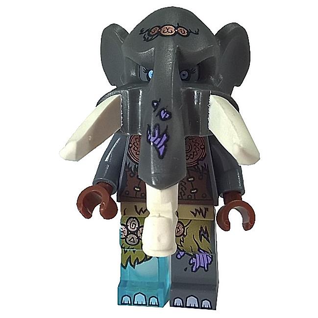 Front view of the LEGO Chima Maula minifigure (loc157). The figure wears a large, dark grey elephant headpiece featuring large white tusks, purple markings on the trunk, and decorative tribal markings on the forehead. The body has dark blue/grey sleeves over a brown torso printed with tribal patterns, and the lower body features dark green/olive printing over blue legs, suggesting the character is partially submerged or standing in water/ice, with transparent light blue feet. The hands are reddish-brown.