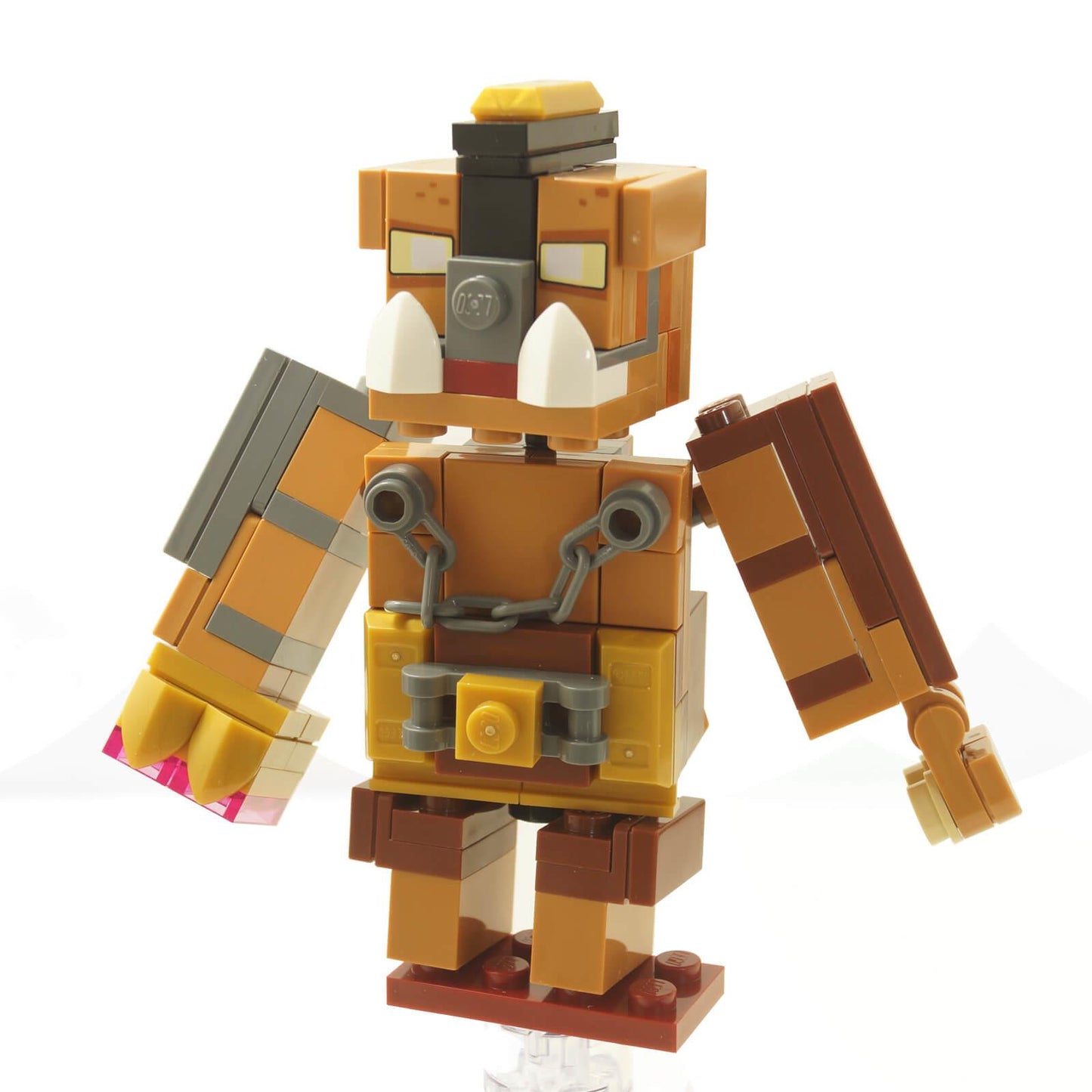Frontansicht des Großen Hogs LEGO® Minecraft Boss-Mob-Figur aus dem Set 21272, mit Stoßzähnen, Ketten, blockartigem braunem Design und beweglichen Armen