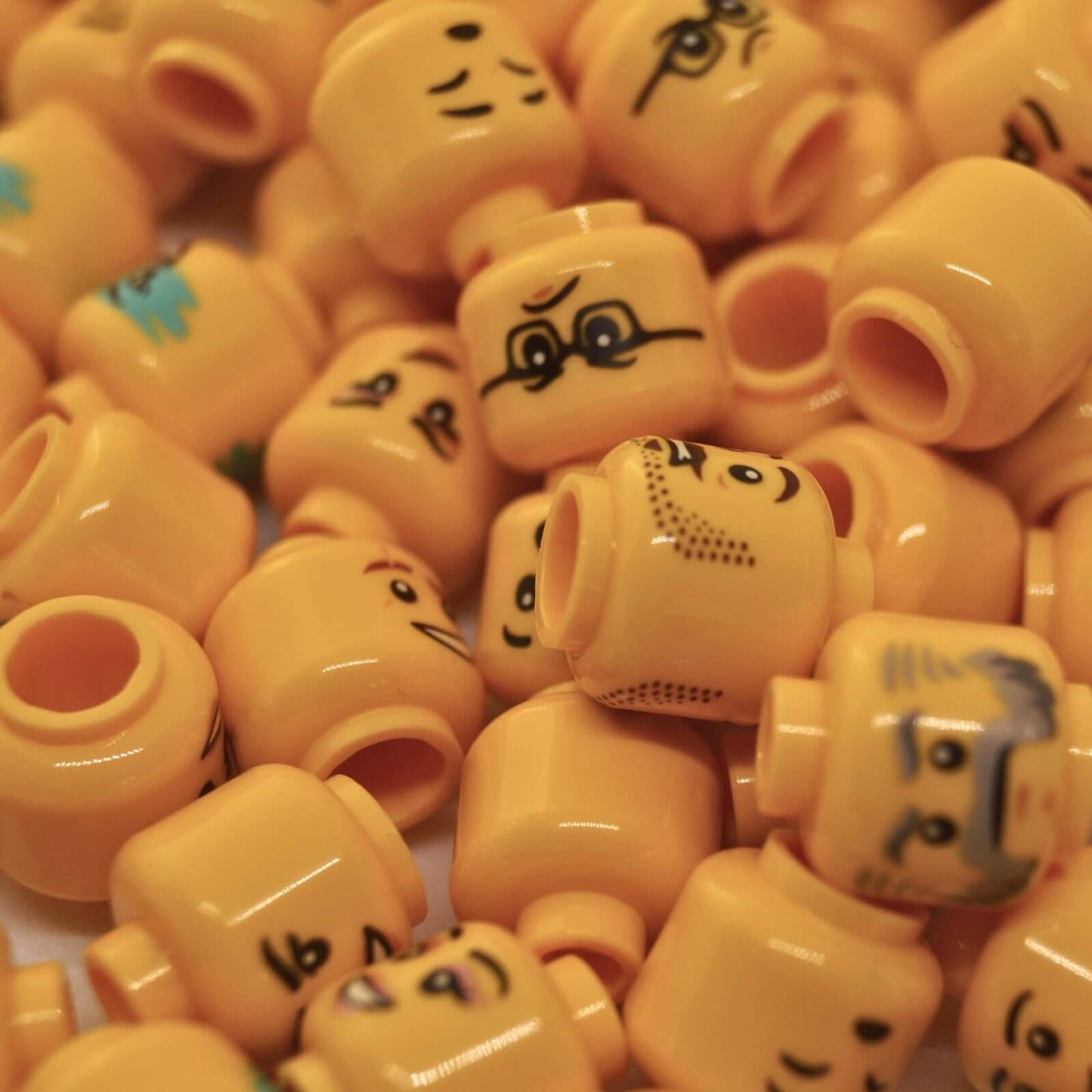 Großmenge von LEGO® gelben Minifigurköpfen mit verschiedenen Gesichtern und Drucken, zufälliges 10er-Pack