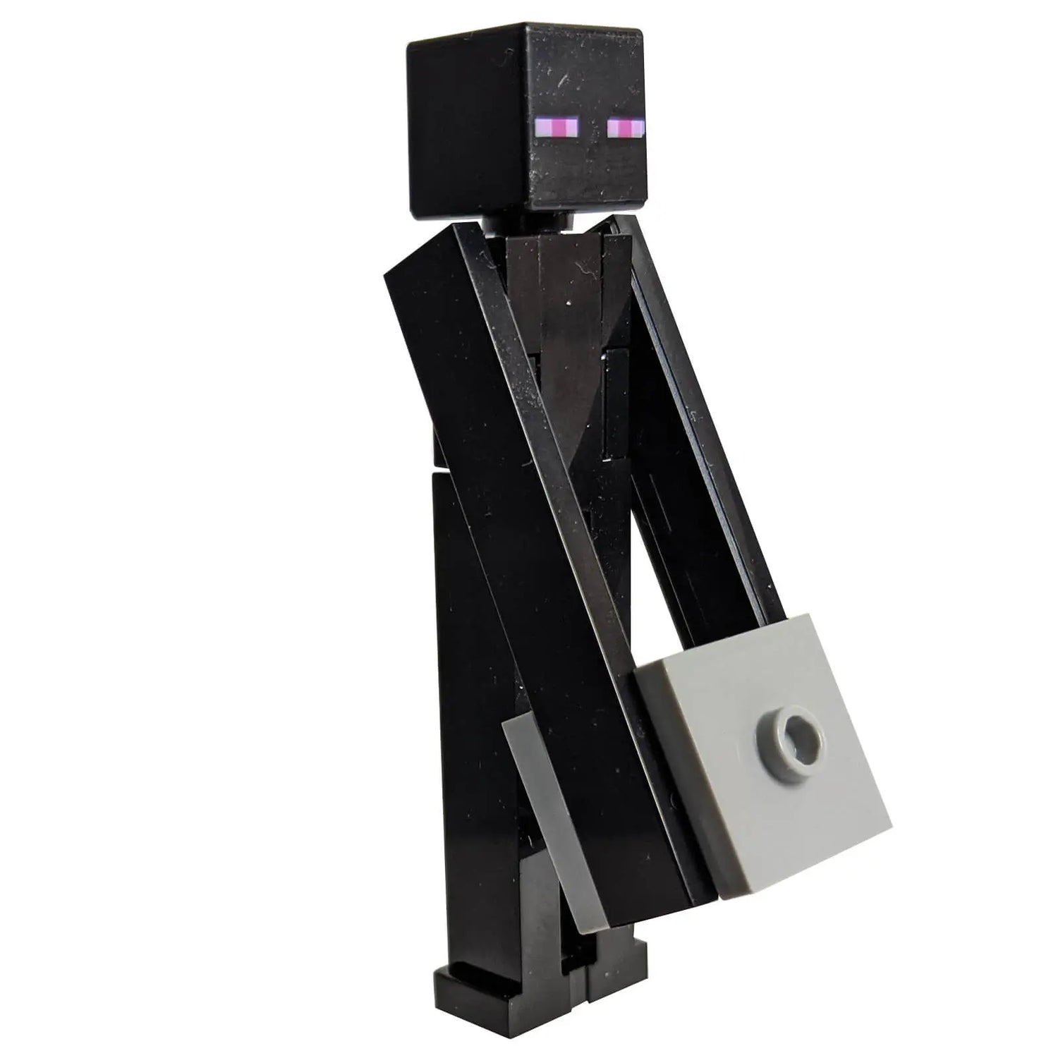 LEGO® Minecraft Enderman Minifigure carrying a gray block – Tall, shadowy design with iconic purple eyes, perfect for recreating scenes in The End dimension.