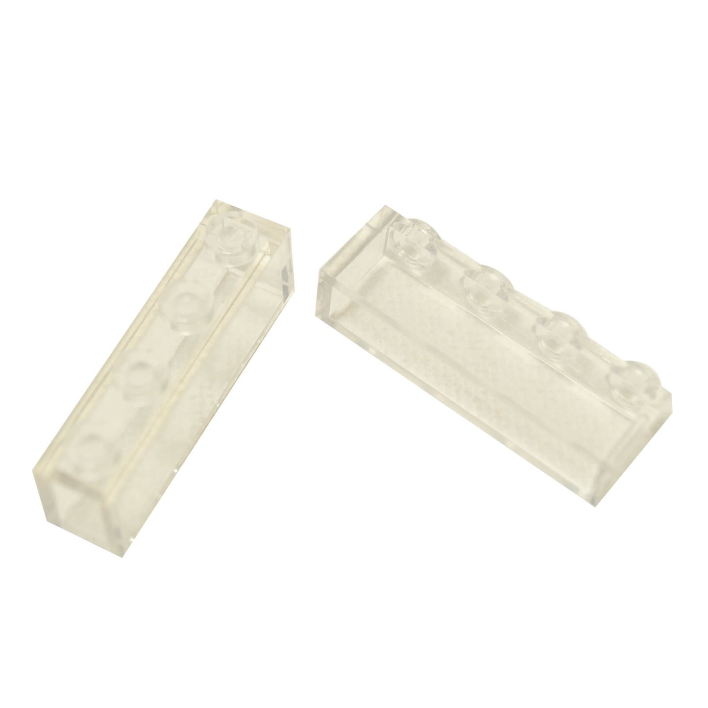 LEGO kostky 1x4 (3066), průhledné, bez vnitřních trubiček, šikmý pohled.