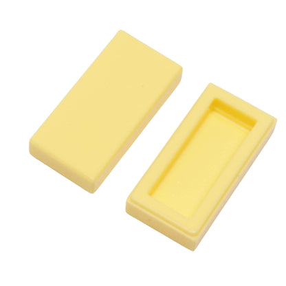 LEGO Tile 1 x 2 part 3069 with smooth rectangular top and recessed underside bright light yellow