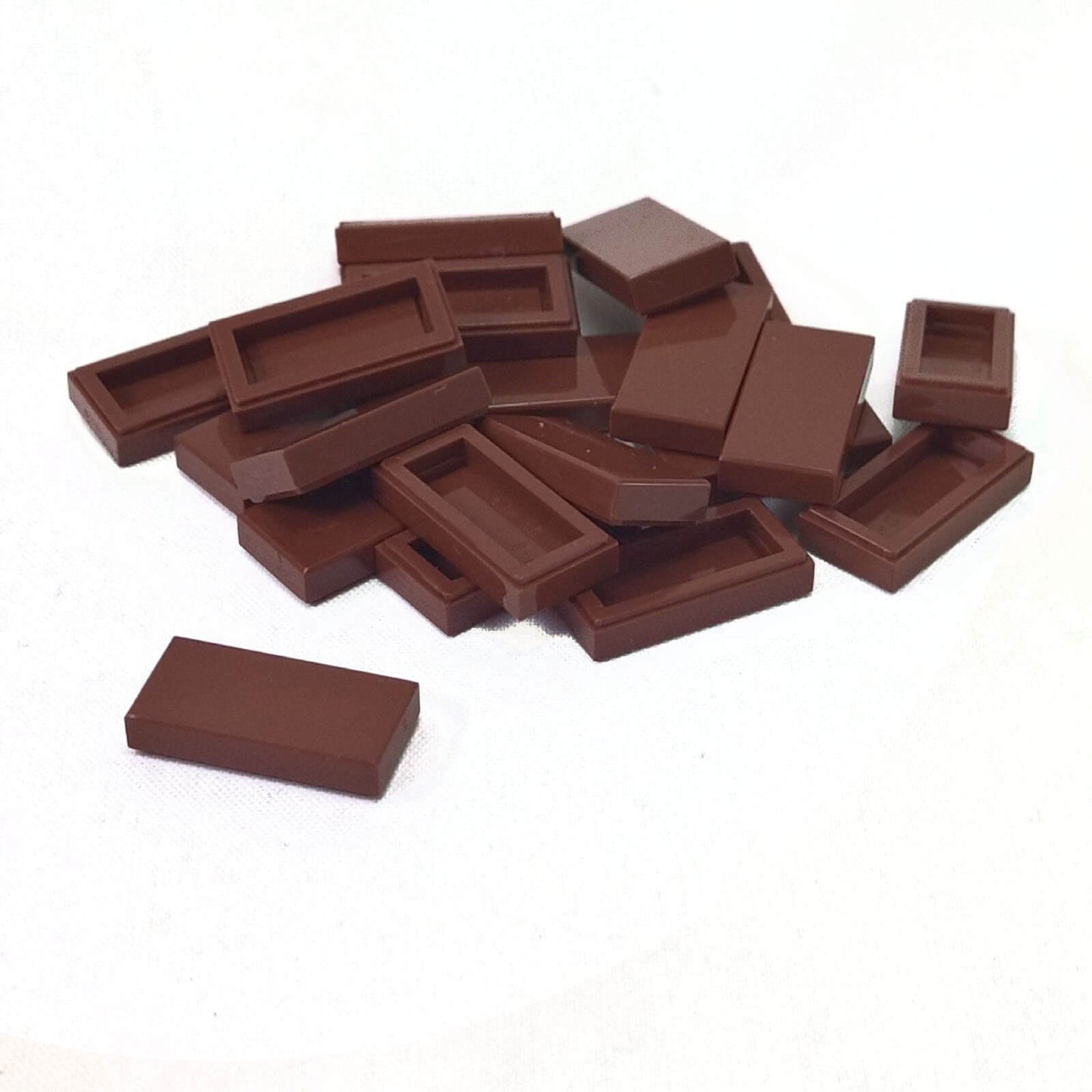 LEGO Tile 1 x 2 part 3069 with smooth rectangular top and recessed underside reddish brown