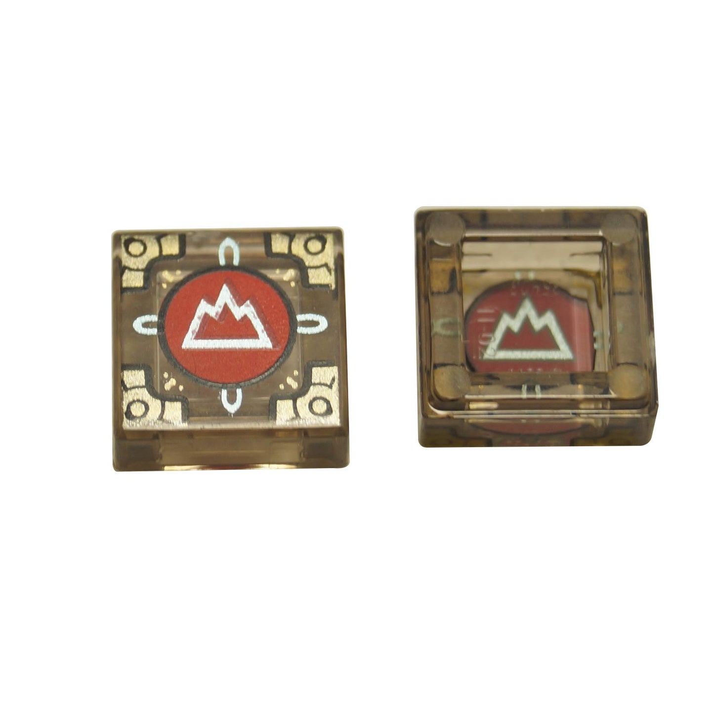 Two views of a LEGO trans-brown 1x1 tile with a metallic light blue mountain symbol on a red circle and gold corners, part of the Dungeons & Dragons Cubic Gate set.