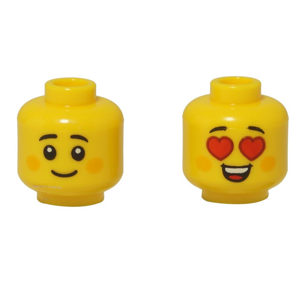 Dwie żółte głowy minifigurek LEGO o podwójnym wyrazie twarzy: jedna uśmiecha się po prostu, a druga ma emoji w kształcie serca.