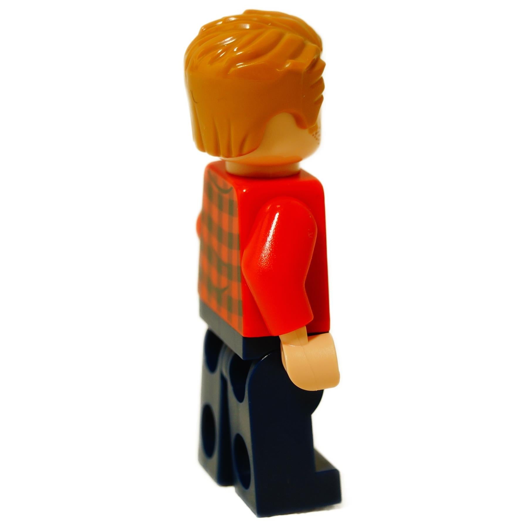 Side view of LEGO Owen Grady minifigure showing orange hair, red flannel shirt sleeves, and dark blue pants.