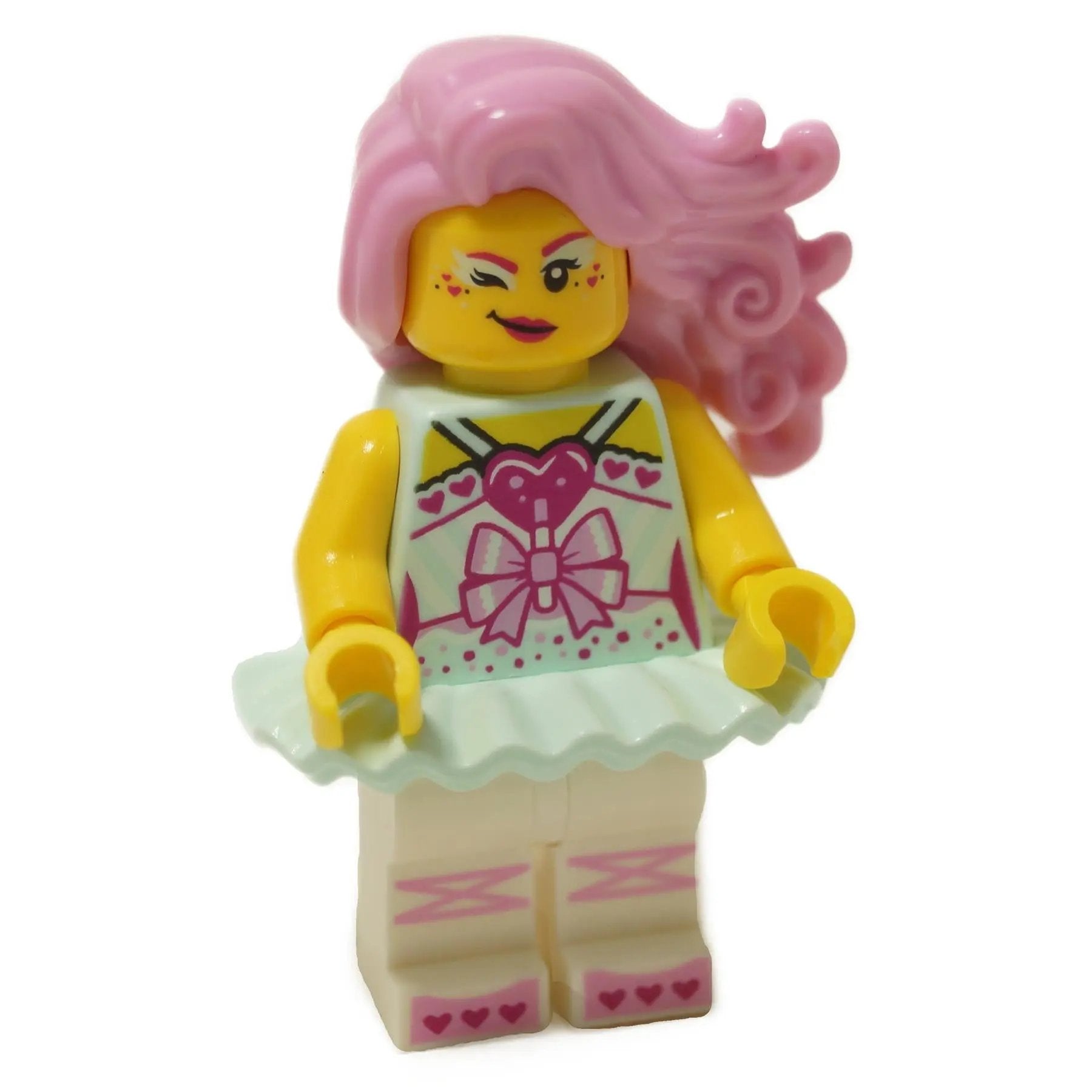 LEGO® VIDIYO minifigure with long pink hair, winking face, and a decorated dress featuring a heart, bow, and pink accents, with a white skirt and patterned legs.