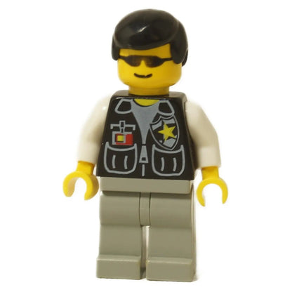 Minifigura de LEGO Policía Sheriff (cop037) con gafas de sol, un chaleco negro con una insignia de estrella amarilla, una camisa blanca, piernas gris claro y cabello negro.