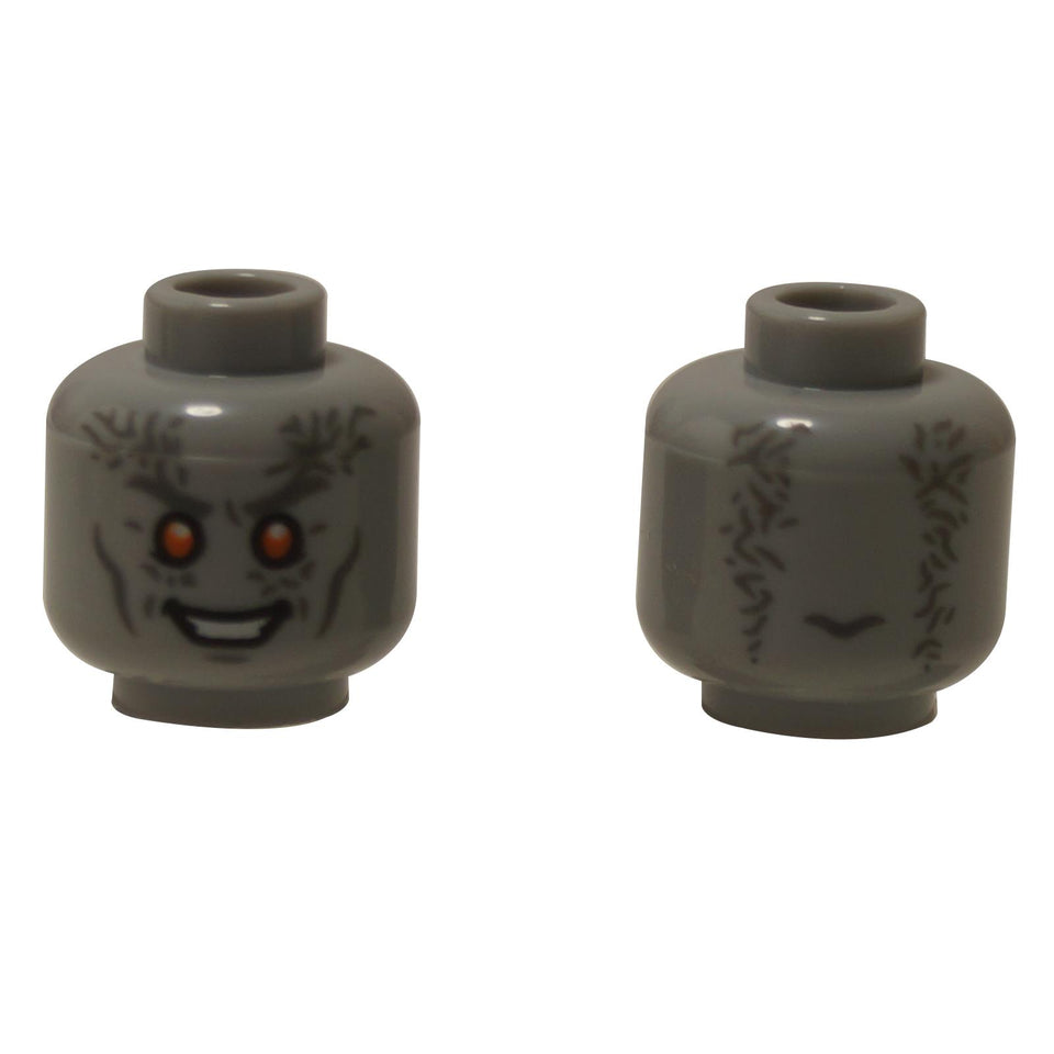 Vista frontale e laterale alternativa della testa del minifigura aliena LEGO® (3626pb3018) in grigio bluastro, con occhi arancioni luminosi, denti bianchi affilati e dettagli scuri delle rughe che si estendono attorno ai lati.