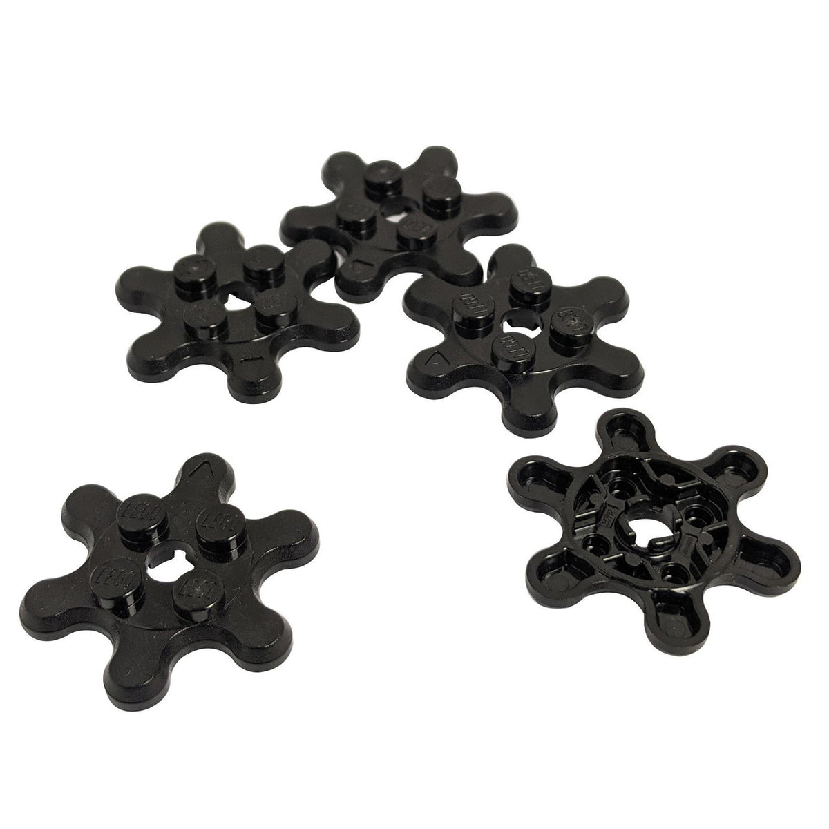 Five black LEGO 35442 plates with 6 gear teeth or flower petals.