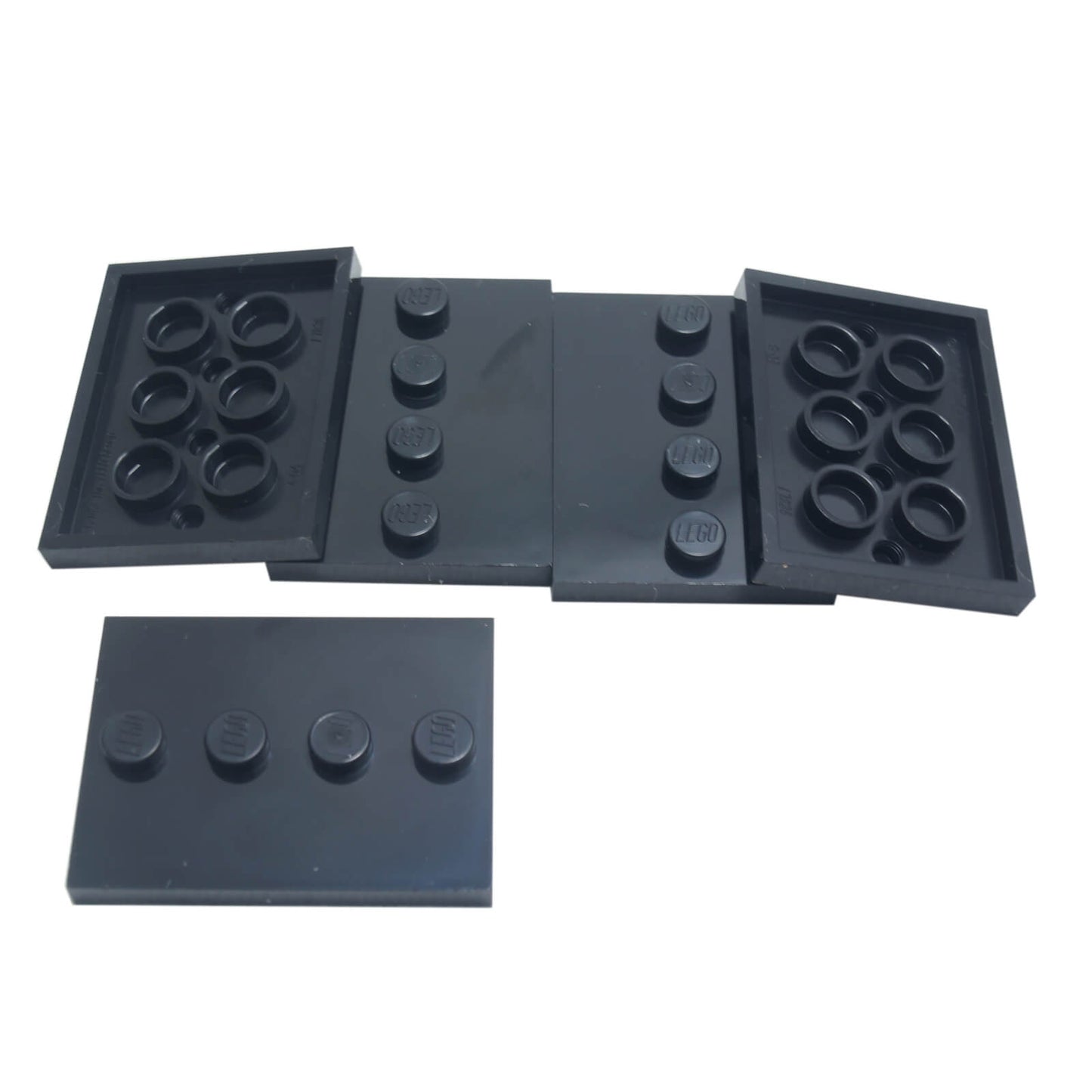Black LEGO® modified 3 x 4 tile with four centered studs, ideal for decorative builds and detailing
