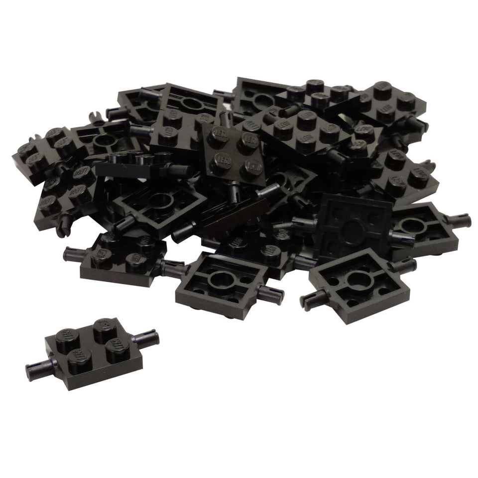 Pile of black LEGO Plate 2x2 with Wheels Holder pieces (4600) showing studs and axle pins.