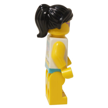 Side view of LEGO Beach Bae mini-doll showing black ponytail and pink sunglasses on yellow head.