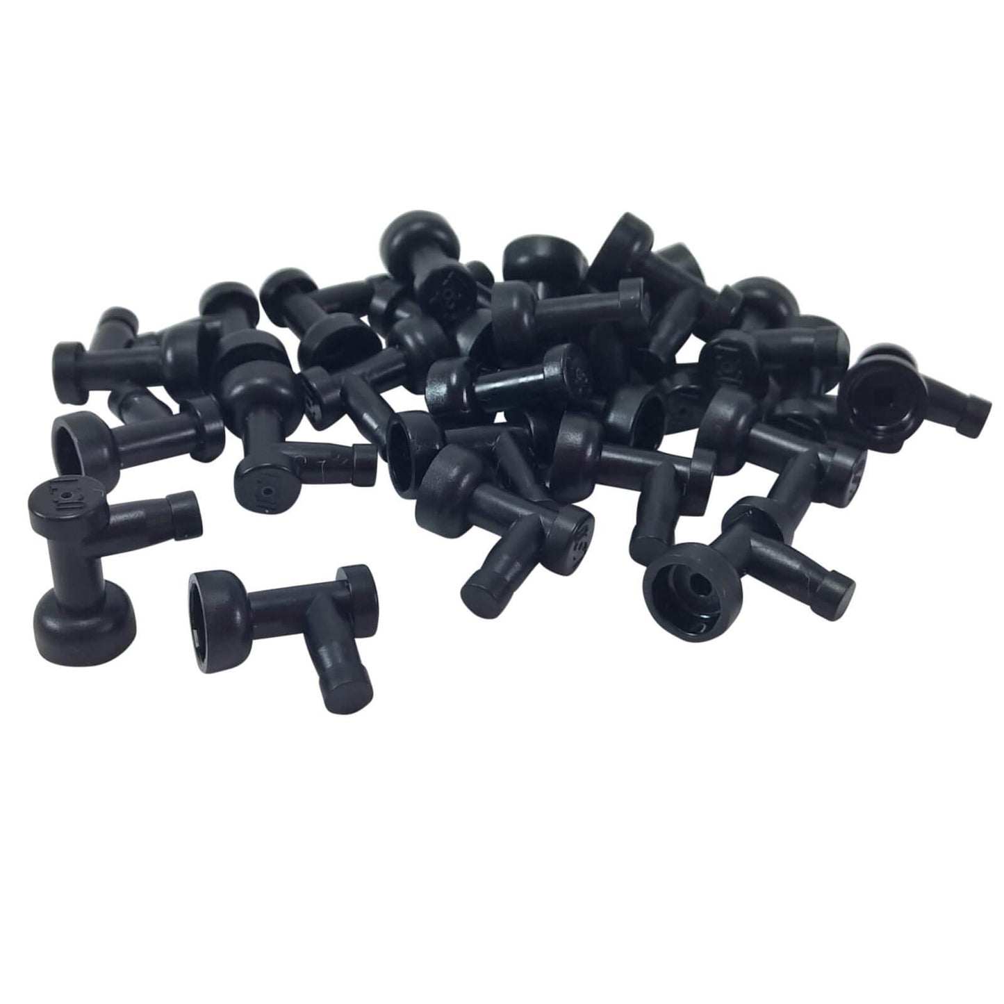 A pile of numerous black LEGO Part 4599b (Tap 1 x 1 without Hole in End) pieces scattered against a white background, showing their T-shape with a flared cup end.