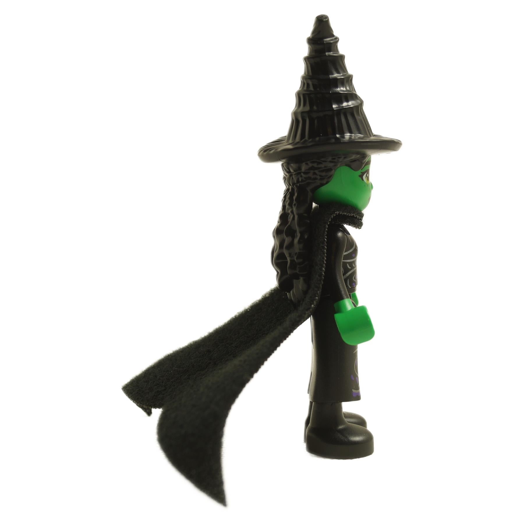 Side view of LEGO® Elphaba mini-doll wck008 with green skin, black dress, cape, and tall witch hat
