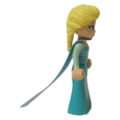 Side view of LEGO Elsa mini-doll showing her blonde braid, light blue dress, and long, sheer blue cape trailing behind her.