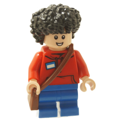Vista frontal de Henry LEGO® minifigura de la película Minecraft (min217) del set 21272, con cabello rizado negro, sudadera roja, piernas azules y mochila marrón