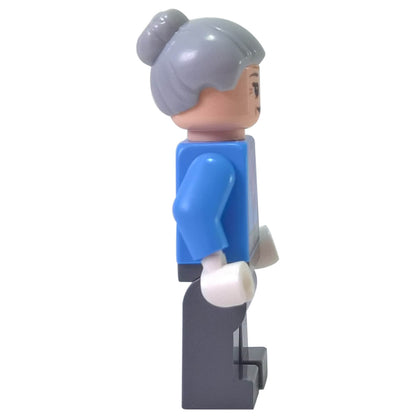 The LEGO Aunt May minifigure (sh272) in new condition, wearing a blue jacket with a lavender scarf and her gray hair in a bun. Sideview