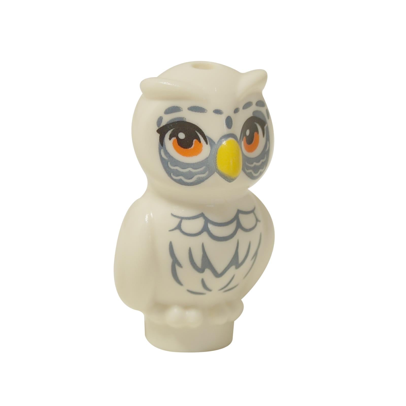  White LEGO® Friends owl figure (21333pb06) standing, with large orange eyes, a yellow beak, and detailed sand blue feather printing on its chest and around its eyes.