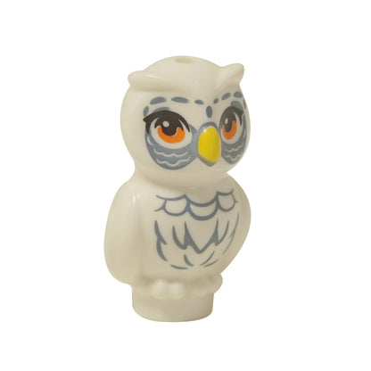  White LEGO® Friends owl figure (21333pb06) standing, with large orange eyes, a yellow beak, and detailed sand blue feather printing on its chest and around its eyes.