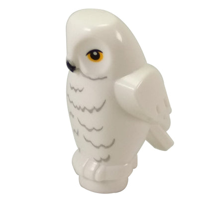 Side profile view of the white LEGO Hedwig Owl figure, showcasing its rounded head shape, molded wings, and the transition to its base/feet.