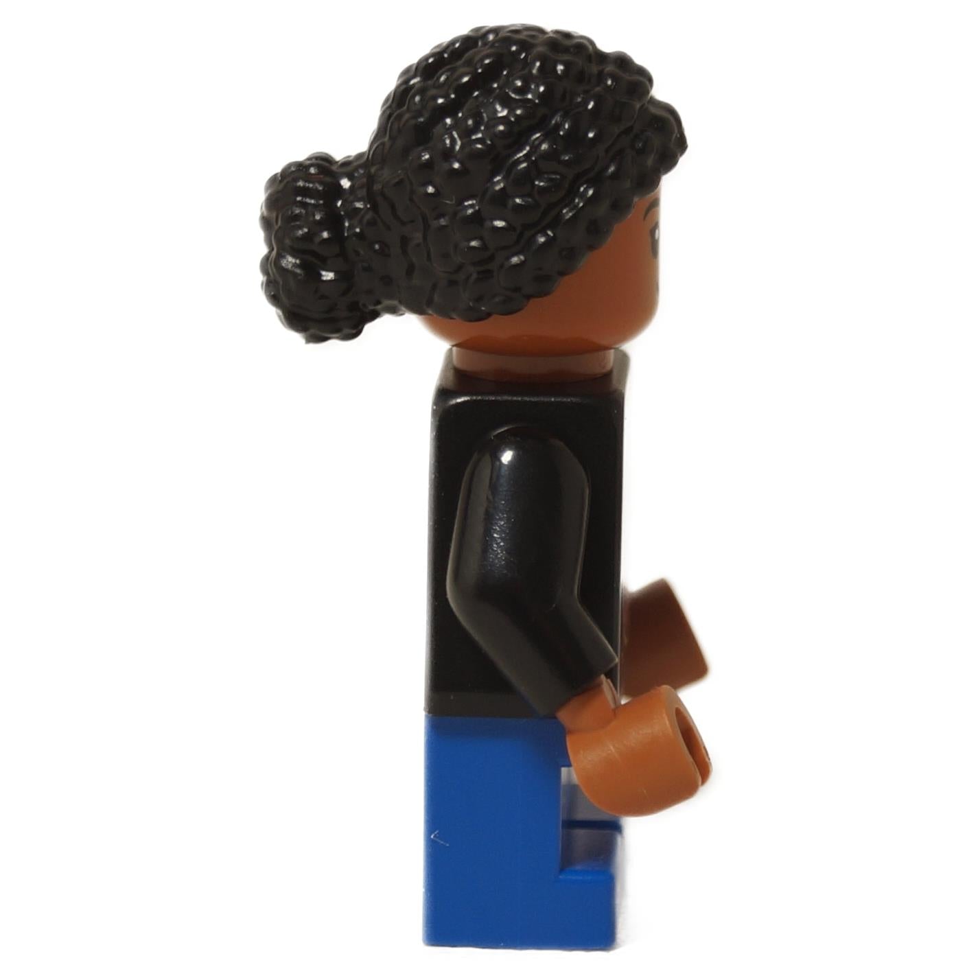 LEGO® Junior Paleontologist girl minifigure with black Jurassic Park logo shirt, blue short legs, and black braided hair, side profile view