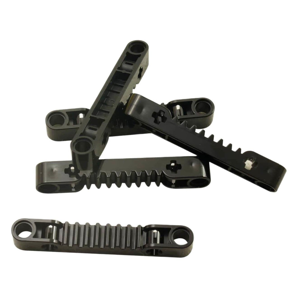 Une pile de cinq pièces de crémaillère LEGO Technic noire 1x7 (8776) montrant leurs bords dentelés et crantés.
