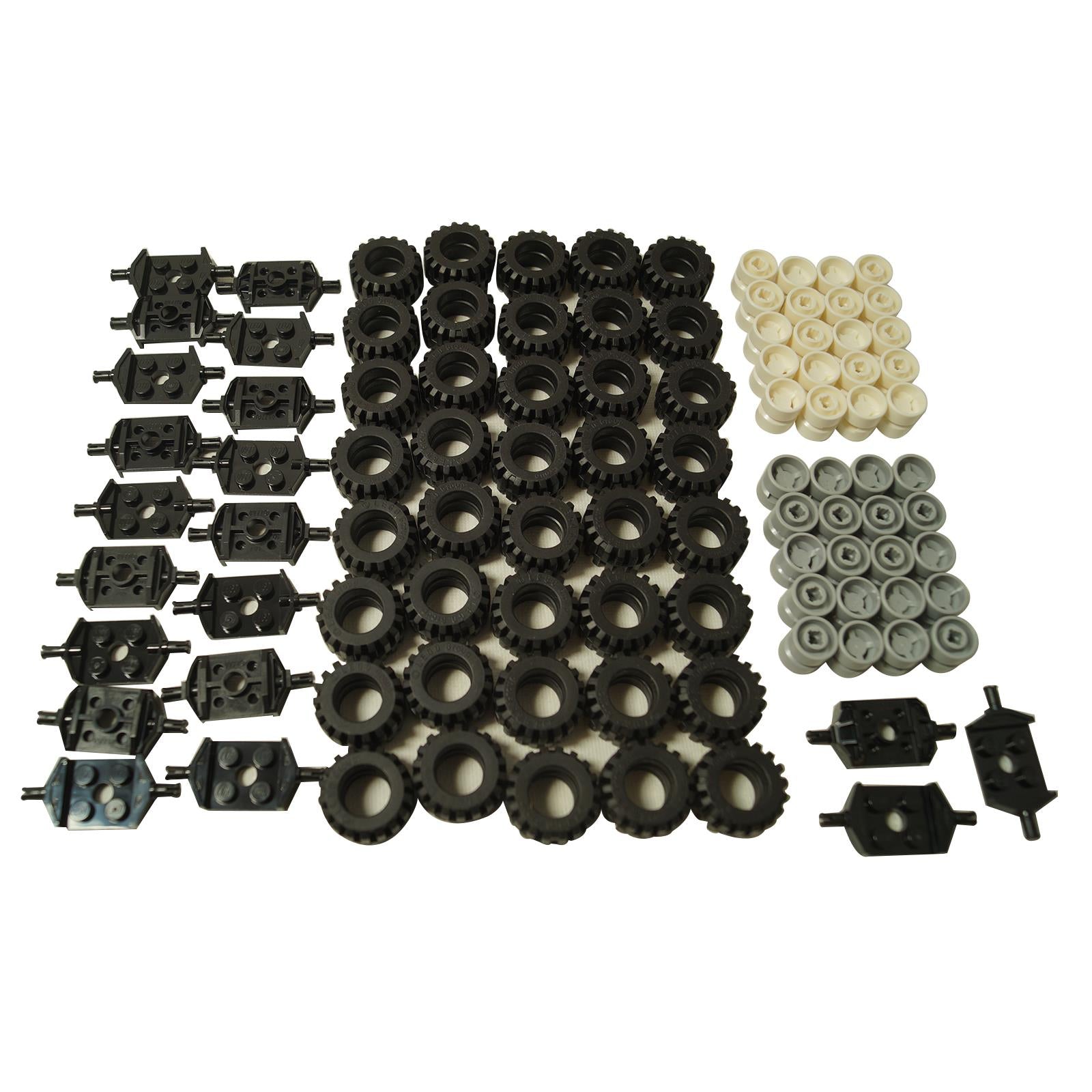 Assortment of LEGO Technic wheel parts: black studded tires, light tan and light bluish-gray rims, and black axle connector plates.
