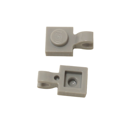 Light bluish gray LEGO® modified plate 1 x 1 part 61252 shown from two angles with single stud and open horizontal O clip
