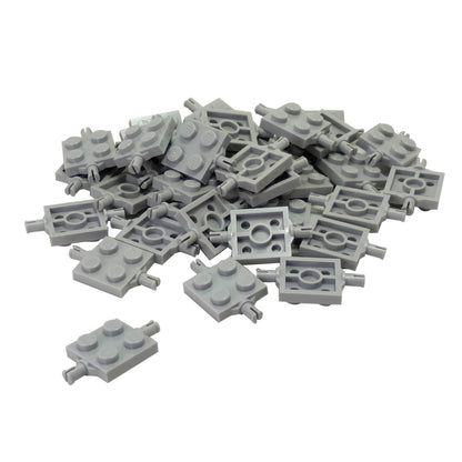 Pile of light bluish-gray LEGO Plate 2x2 with Wheels Holder pieces (4600) scattered on white.