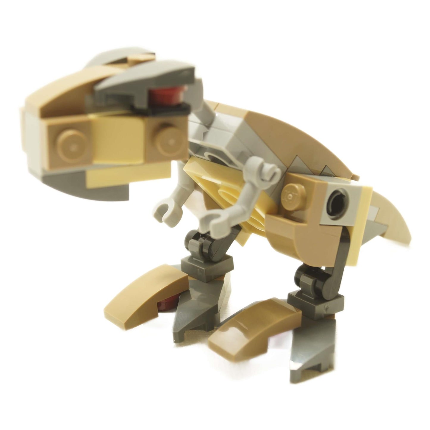 Side view of LEGO® mini Tyrannosaurus Rex brick-built dinosaur in tan and light gray with articulated legs, short arms, and hinged jaw
