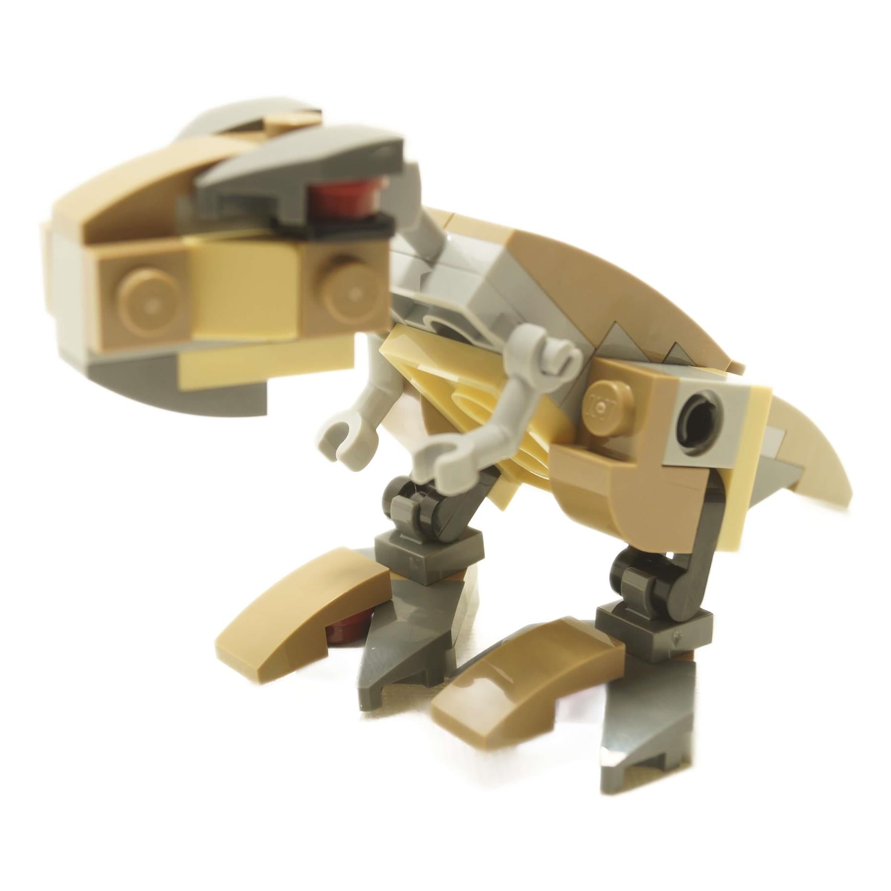Side view of LEGO® mini Tyrannosaurus Rex brick-built dinosaur in tan and light gray with articulated legs, short arms, and hinged jaw
