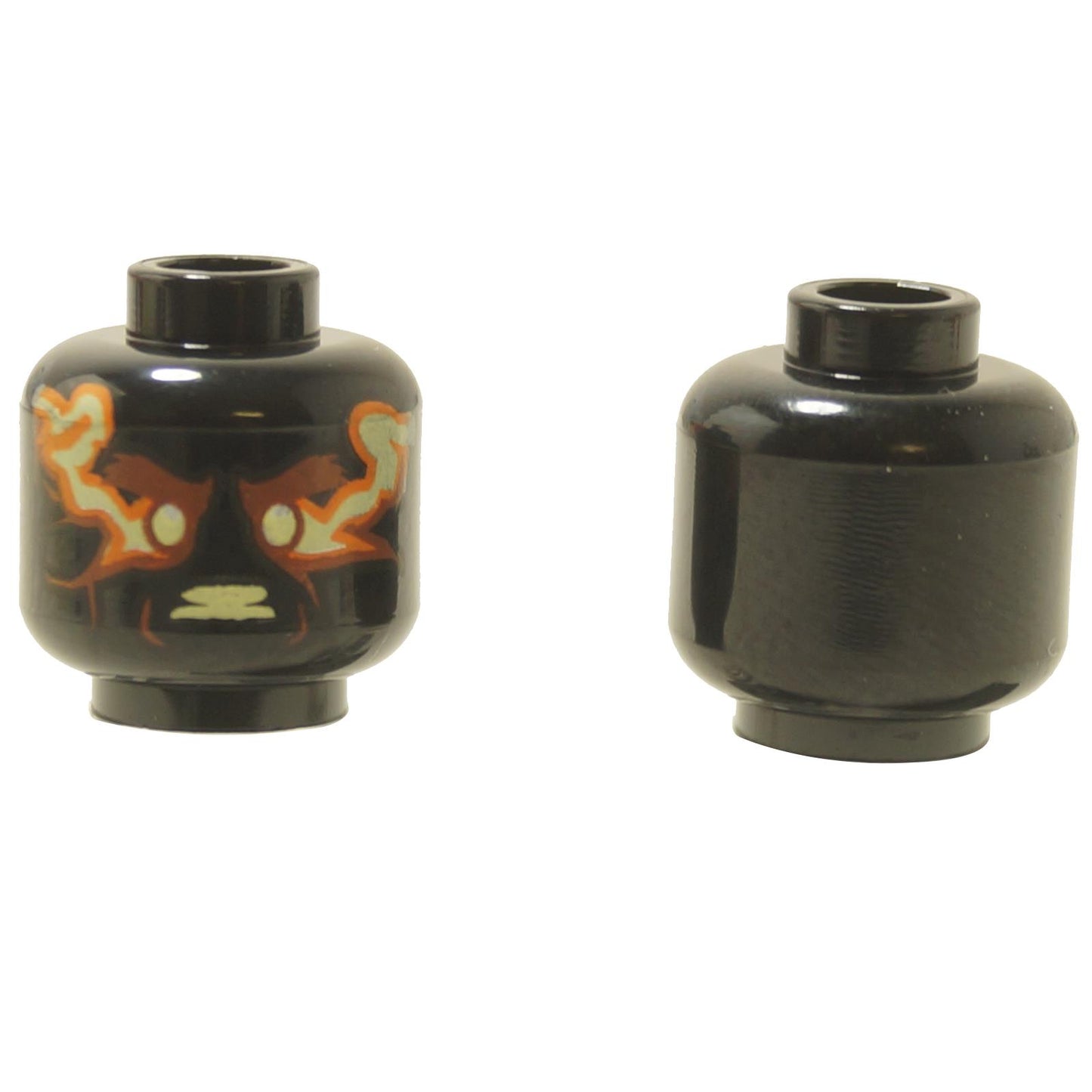 Two black LEGO alien heads (3626pb2632) showing a decorated face with yellow eyes and a plain black back.