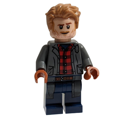  Minifigure Owen Grady de LEGO Jurassic World montré de face. Il porte une veste grise sur une chemise en flanelle à carreaux rouges et a une expression souriante avec une barbe de trois jours.