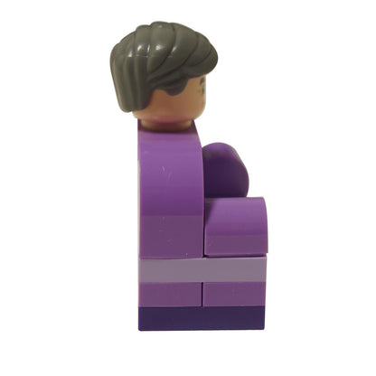 Vista lateral de la figura mostrando la cabeza canosa que se eleva de la estructura de sillón curvado de LEGO púrpura.