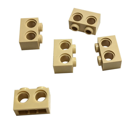 Five tan Technic Bricks 1 x 2 with Holes 32000 from different angles.