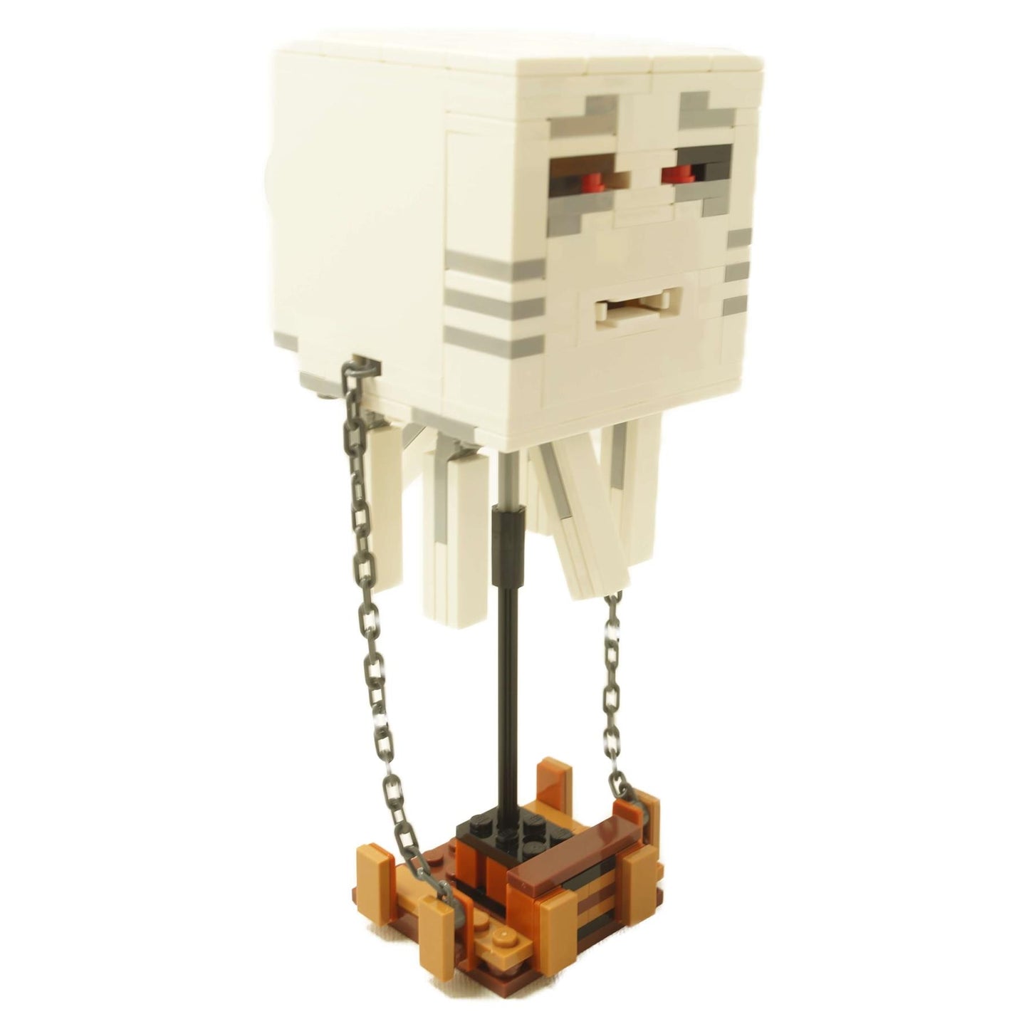 Blanco figura de criatura fantasma voladora construida con ladrillos con cadenas, ojos rojos y soporte de exhibición.
