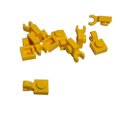 Yellow LEGO® modified plate 1 x 1 part 61252 shown from two angles with single stud and open horizontal O clip